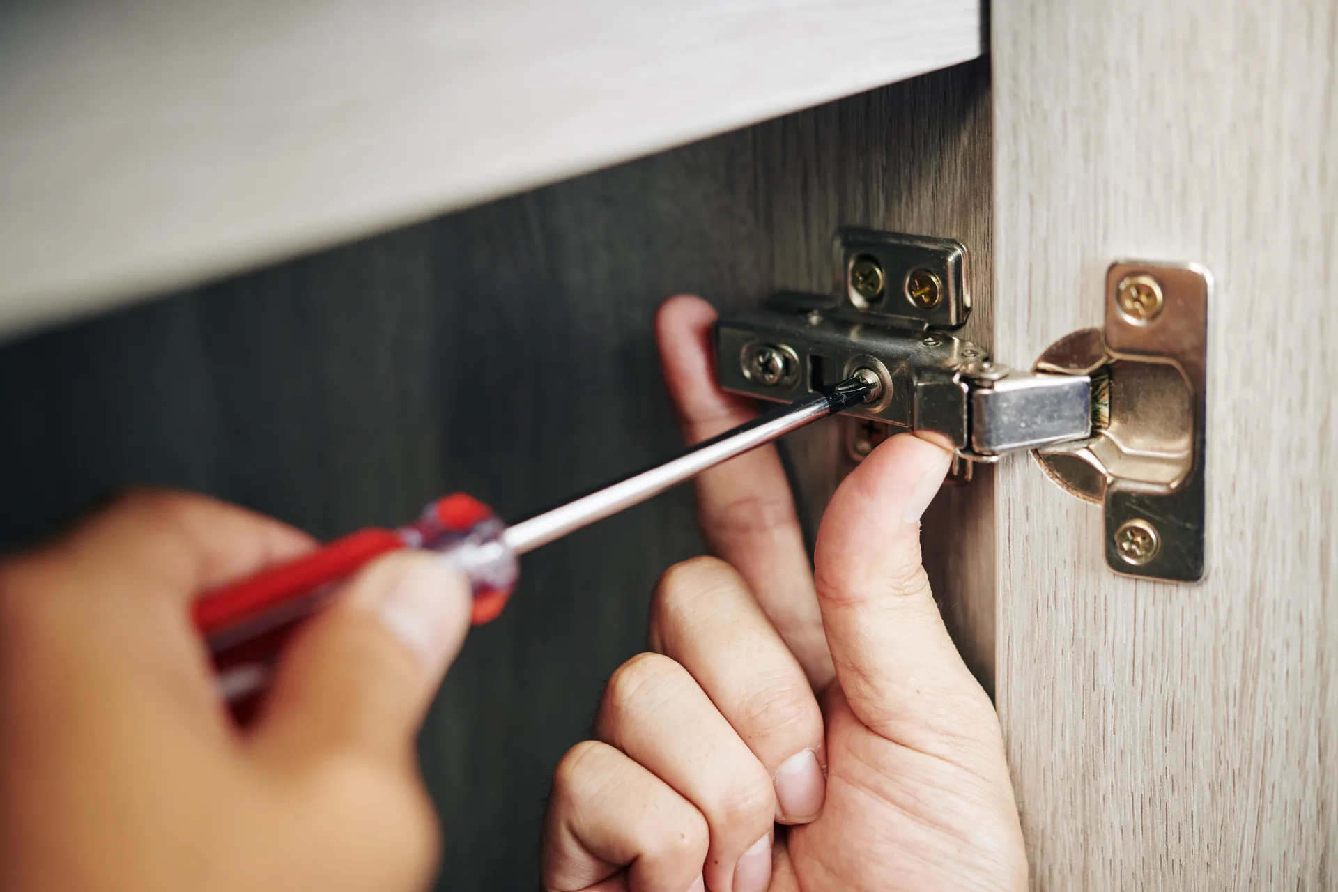 Hands fitting a hinge to a commercial door