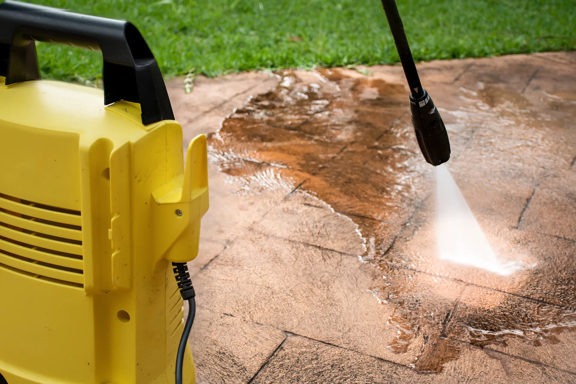 Pressure washing equipment cleaning a hard outdoor surface