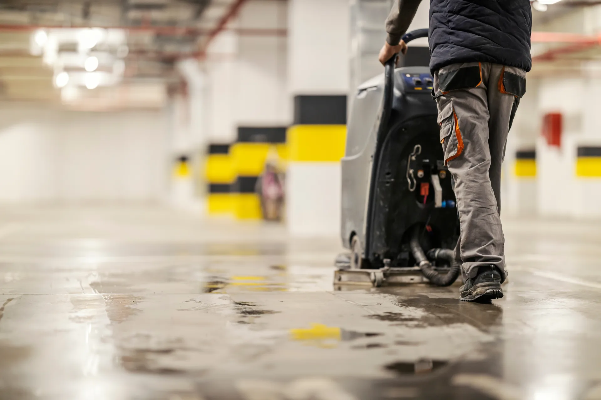 Operator scrubbing a strata car park floor with industrial machine